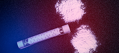 Two piles of cocaine and a rolled up bill representing a cocaine penis.