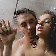 A couple trying a shower sex position for menstrual cramps.