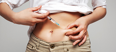 A person injecting bottom growth testosterone into their abdomen. 