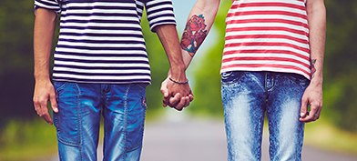 Two people hold hands while standing in the middle of the street.