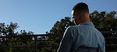 Man-sits-in-chair-facing-away-from-camera