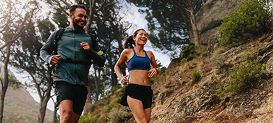 A-man-and-a-woman-running-on-an-outdoor-mountain-trail