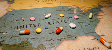 Pills are scattered over a map of the US.
