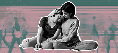 Two women are sitting down and looking sad as one holds the other.