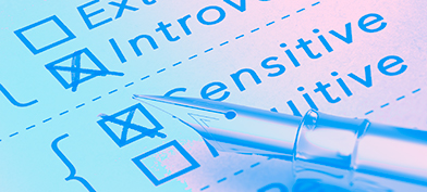 A personality test page has boxes for introvert and sensitive checked by the pen laying on top of it.