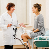 A woman sits talking to her gynecologist during her first visit alone.