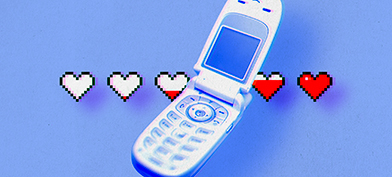 An old flip cellphone is open with a line of white hearts behind it that are filling up with red.