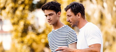 A father walks with his son having a discussion about consent.