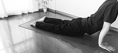 A man stretches his pelvic floor during an exercise on a yoga mat.