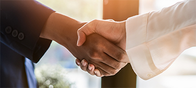 A person with a blue sleeve is shaking hands with someone with a white sleeve.
