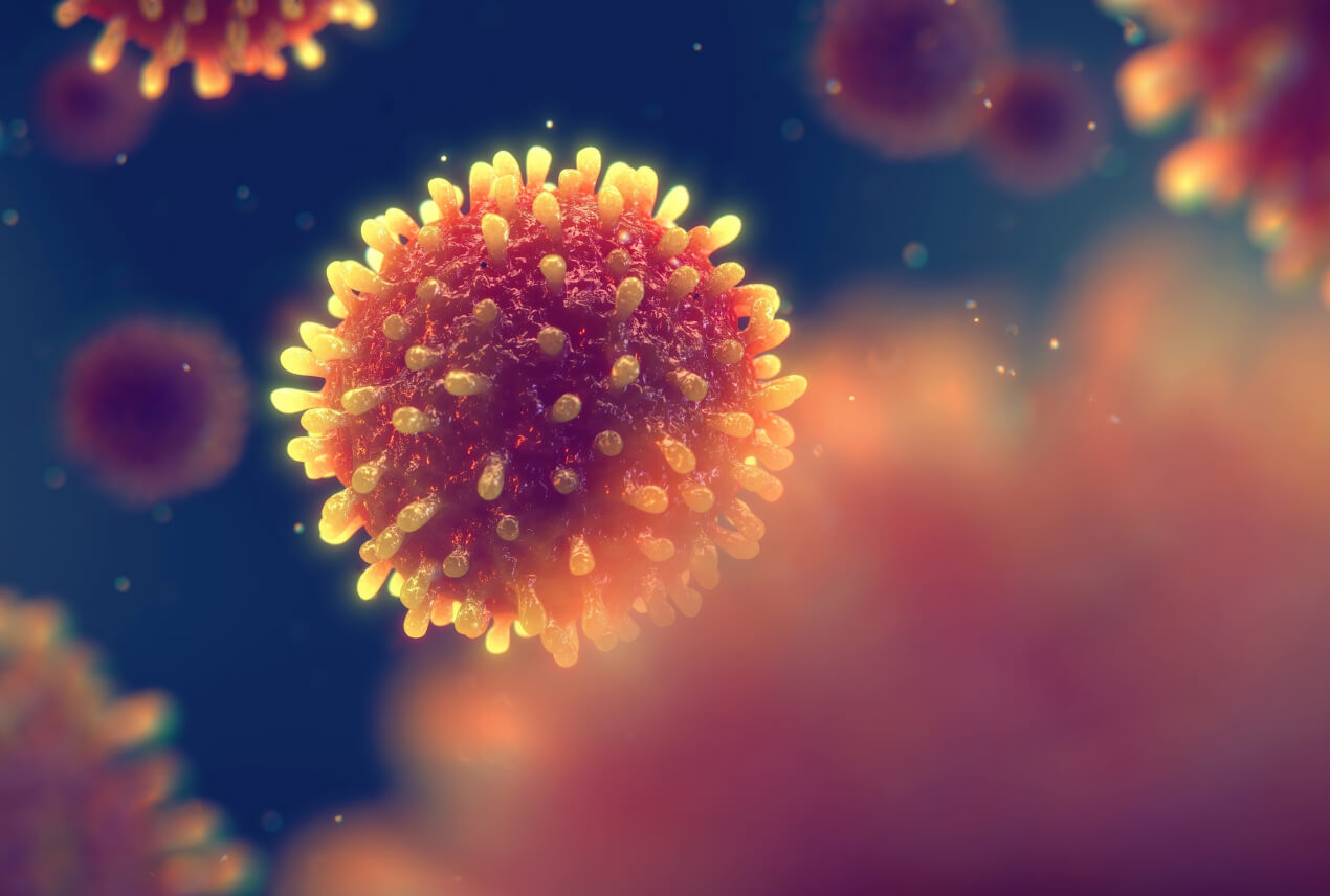 A spikey, orange cell floats in a navy space with out-of-focus cells surrounding it.
