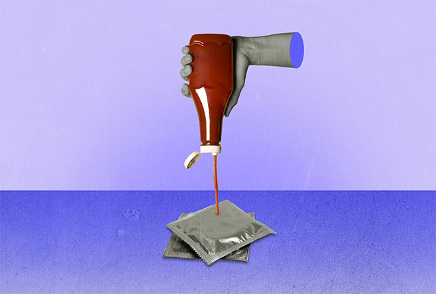 A hand squeezes an upside down bottle of ketchup onto two condoms