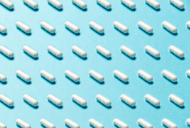 A pattern of white pills is against a light blue background.