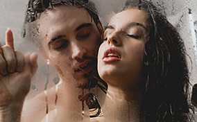 A couple trying a shower sex position for menstrual cramps.