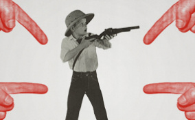 A-surprised-boy-holds-a-gun-while-fingers-point-at-him