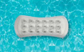 A pool floaty shaped like a menstrual pad, floats in a blue pool.