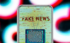 A cellphone has a person with a TV in place of their head and the words FAKE NEWS showing on screen.