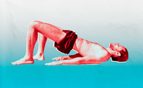 A man does bridge pose on a blue, gradient background.